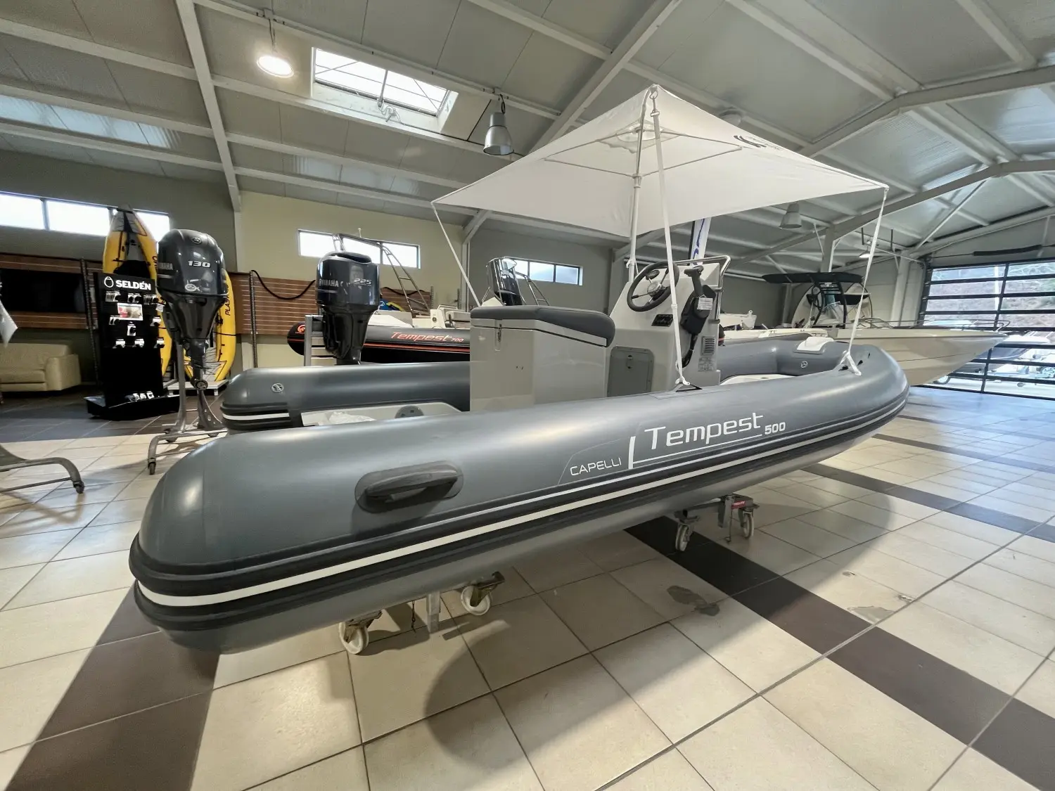 Capelli Tempest 500 — Semi-rigide gris présenté en intérieur, vu de trois quarts avec console et taud.
