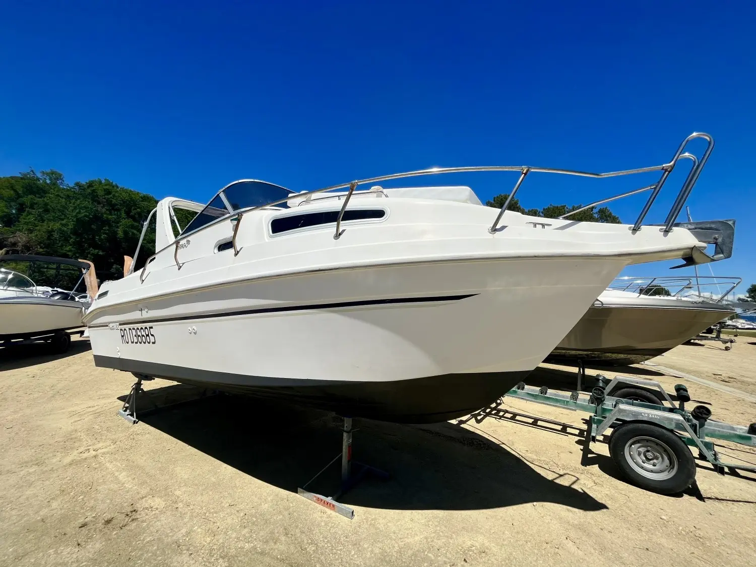 Drago Fiesta 22 — Bateau à cabine blanche présenté sur une remorque dans un chantier nautique.