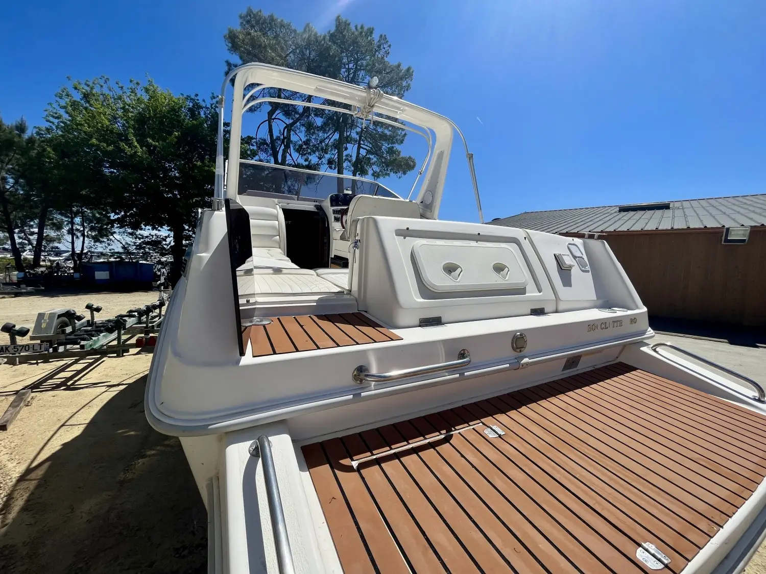 Drago Fiesta 22 — Vue arrière trois quarts d’un bateau blanc avec cockpit et plateforme de bain.
