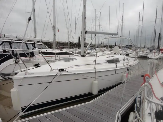 Hunter 31 — Voilier blanc amarré dans une marina, vu de trois quarts par temps couvert.