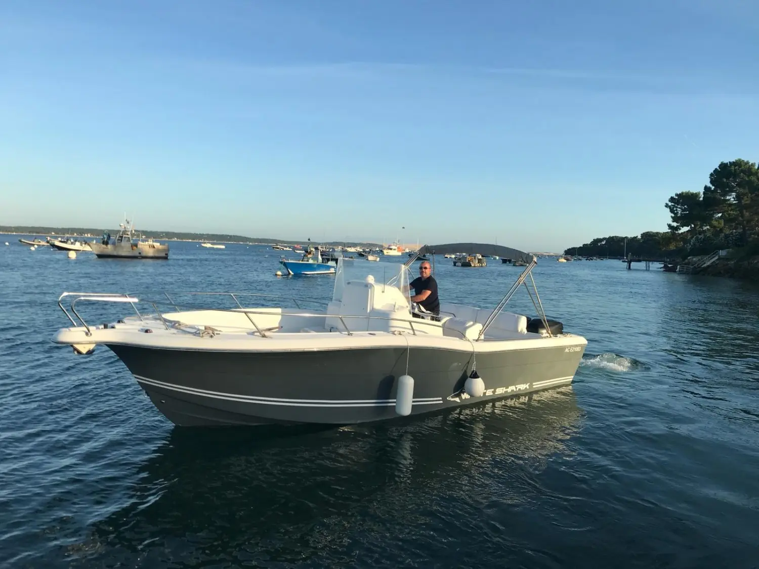 Kelt White Shark 265 — Bateau à moteur blanc et gris photographié au mouillage dans une baie.