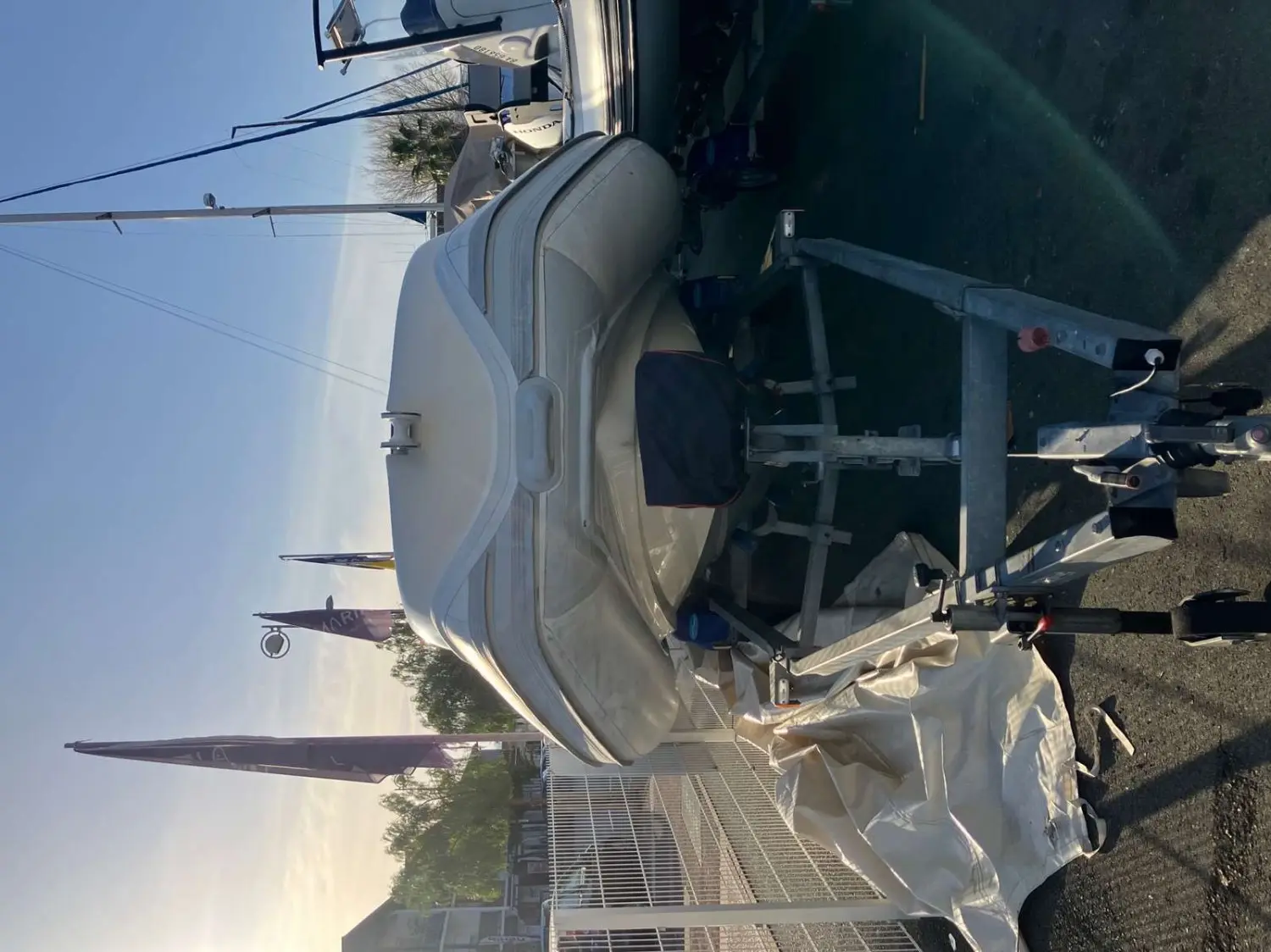 Nautica Led 680 GS — Bateau hors de l’eau sur sa remorque, photographié de travers sur un parking.