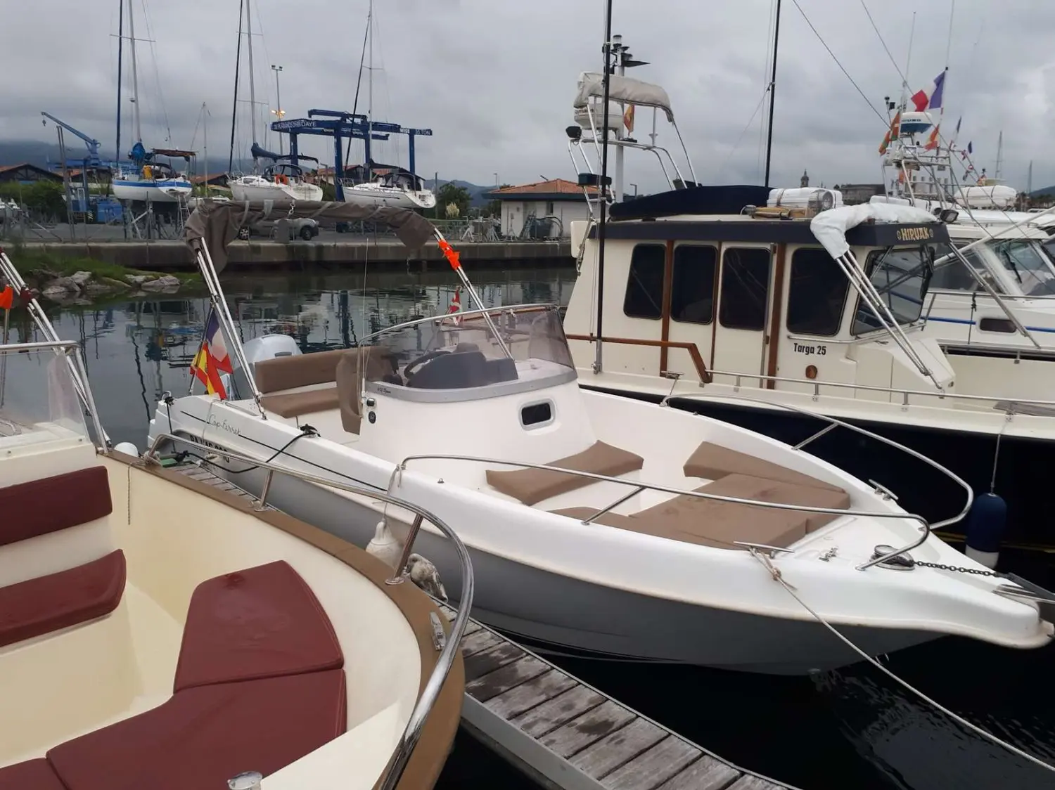 B2 Marine Cap Ferret 672 — Vedette blanche amarrée dans un port, vue de trois quarts avant.