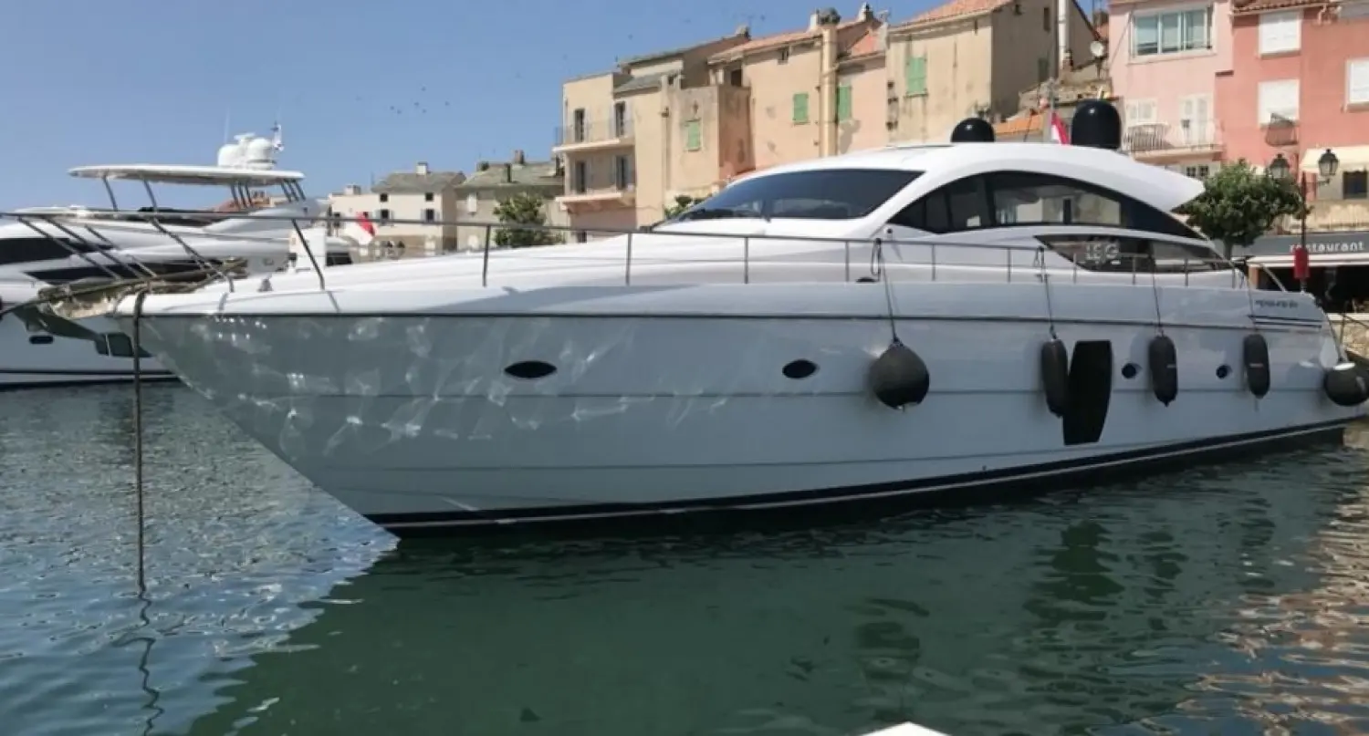 Pershing 64 — Bateau à moteur blanc amarré dans un port, vu de profil tribord.