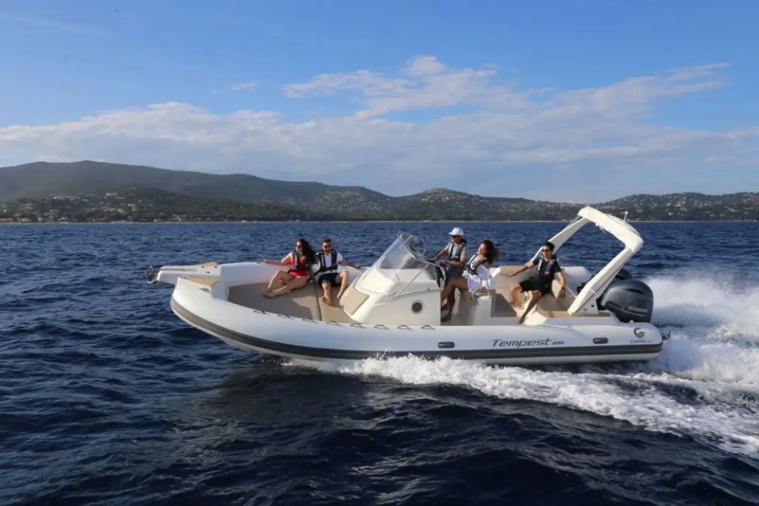 Capelli Tempest 850 — Bateau semi-rigide blanc naviguant au large avec plusieurs passagers à bord.