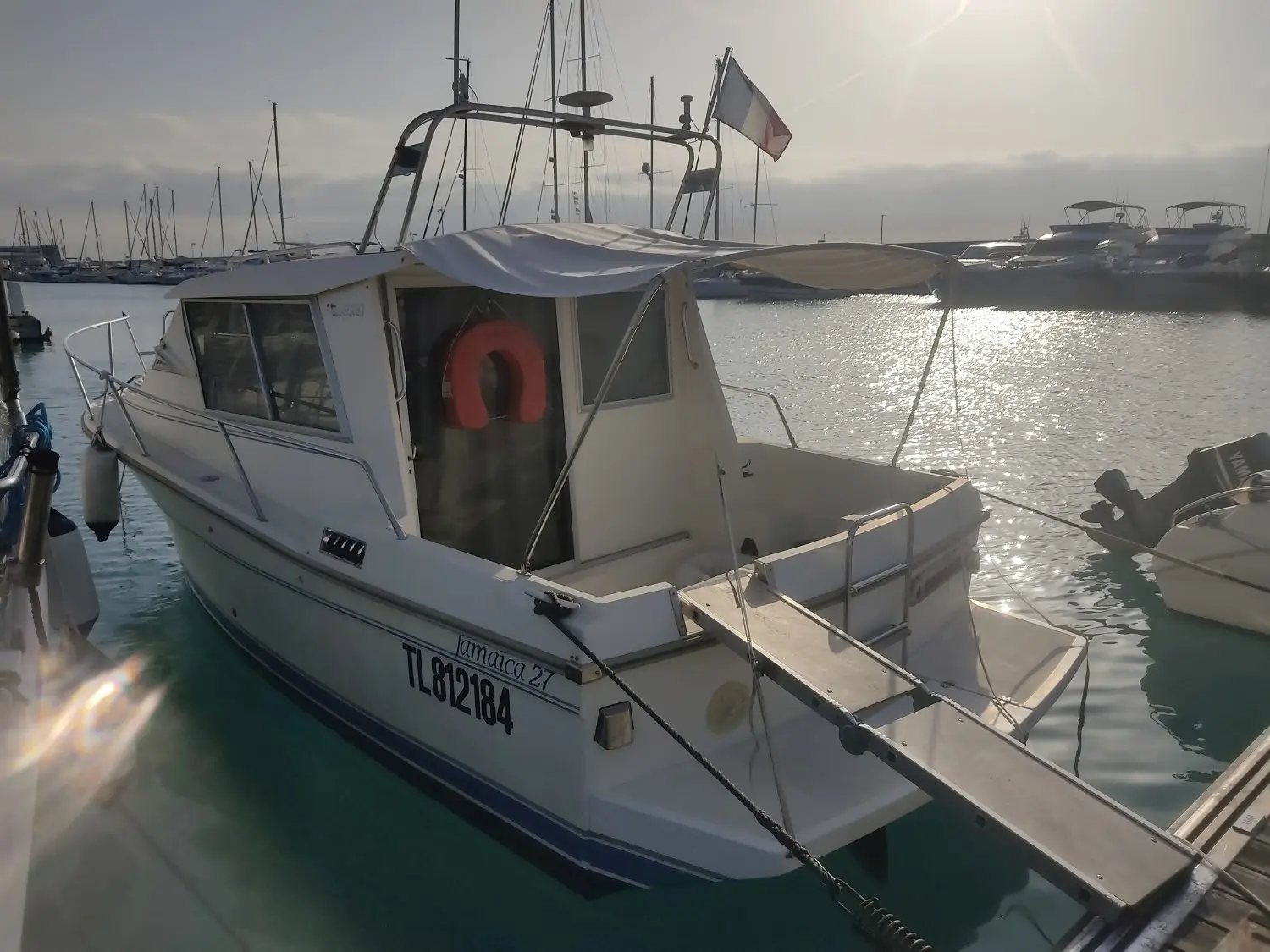 Gibert Marine Jamaica 27 — Bateau à moteur amarré dans un port, photographié de trois quarts arrière.