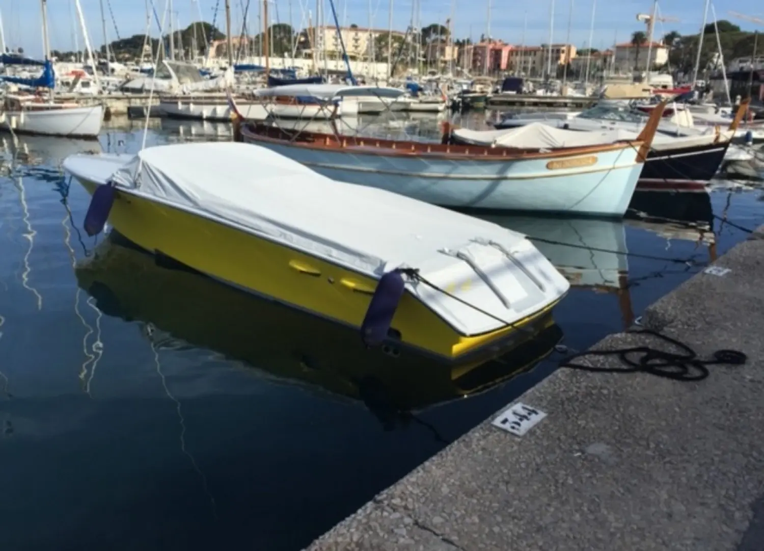 Offshore Marine Monte Carlo 30 — Bateau à coque jaune bâché, amarré dans un port de plaisance.