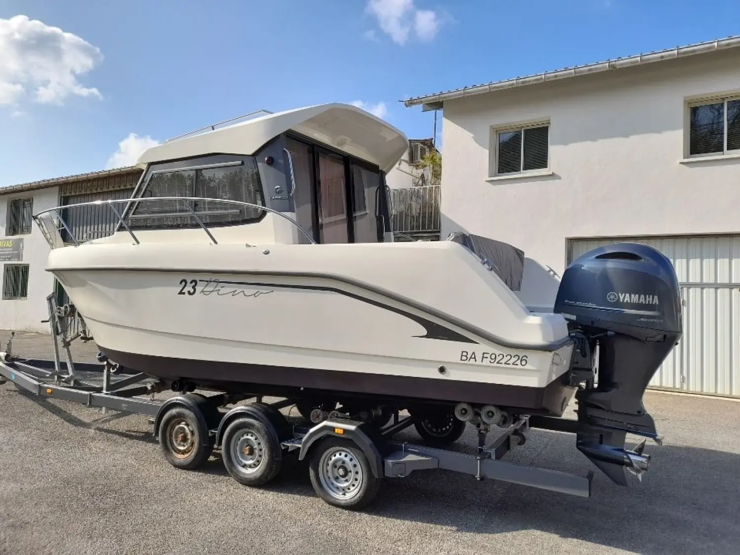 Capelli Dino 23 — Bateau à moteur blanc sur remorque, photographié de trois quarts à terre.