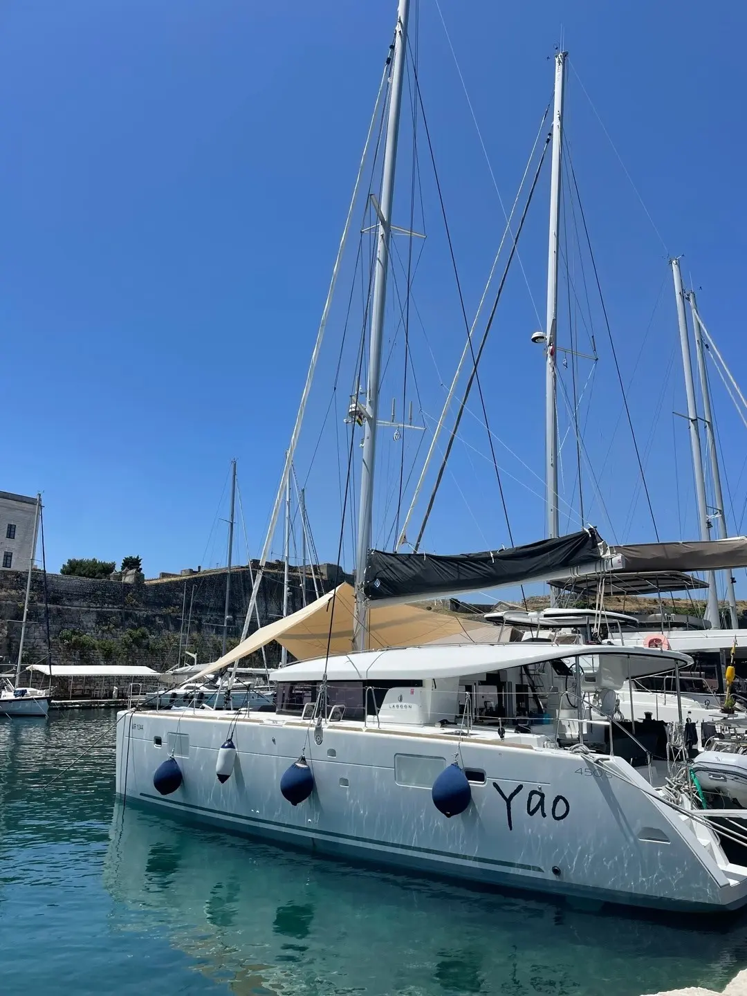 Lagoon 450 — Catamaran blanc amarré dans un port, vu de trois quarts.