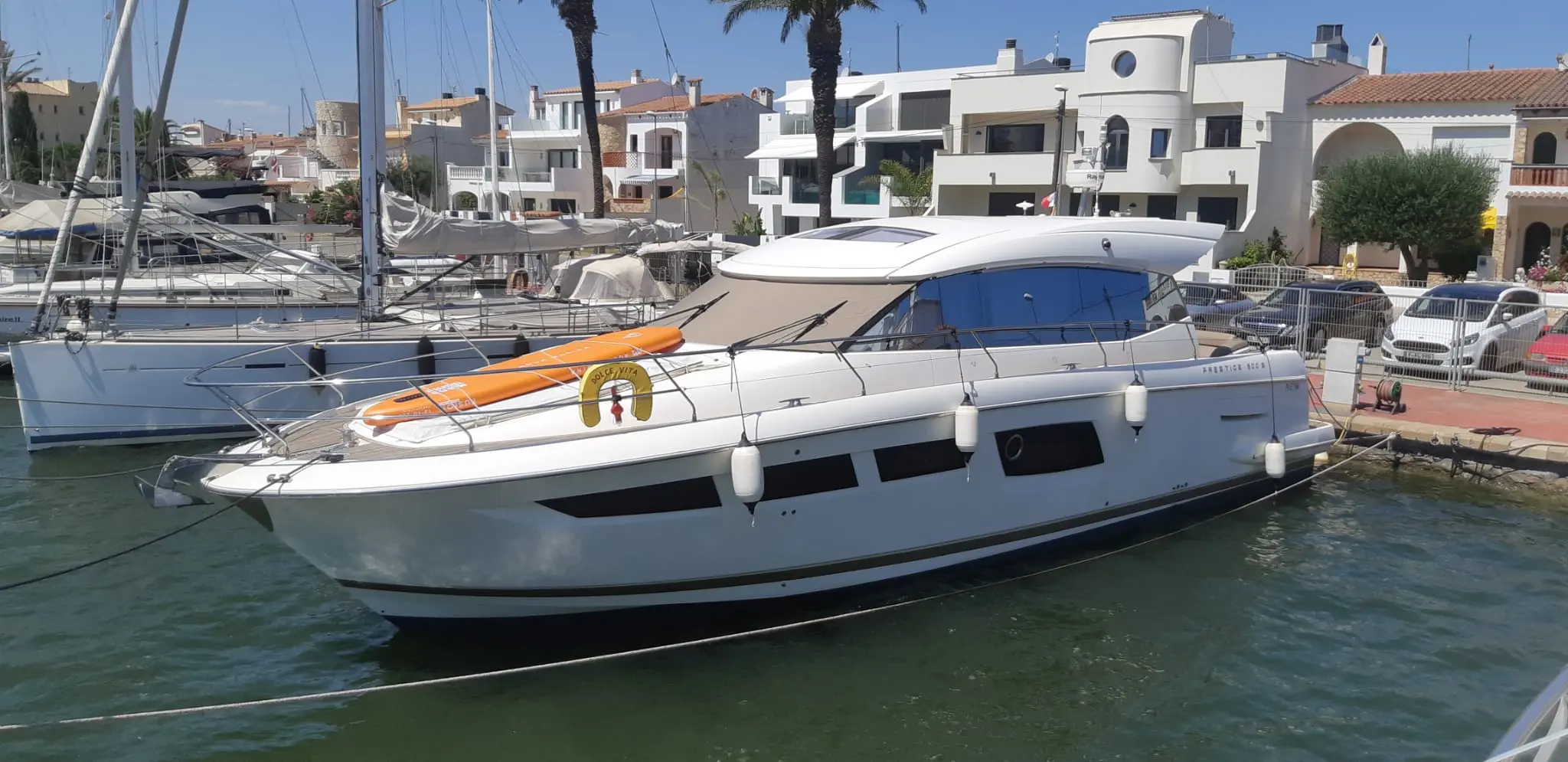 Jeanneau Prestige 500 Fly — Bateau à moteur blanc amarré dans un port, vu de trois quarts bâbord.