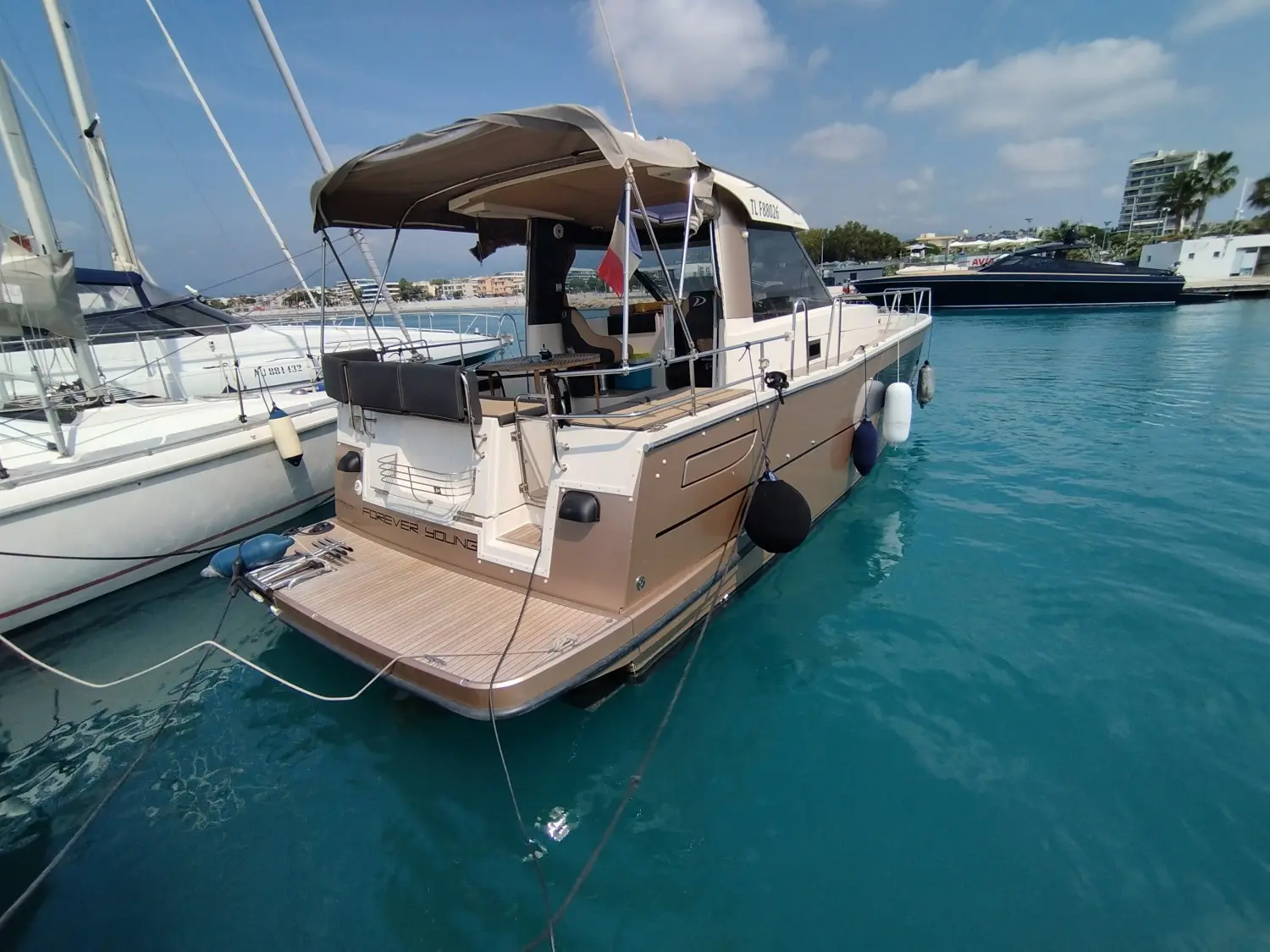 Delphia Escape 1100 Soley — Bateau à moteur amarré, vu de trois quarts arrière dans une marina.