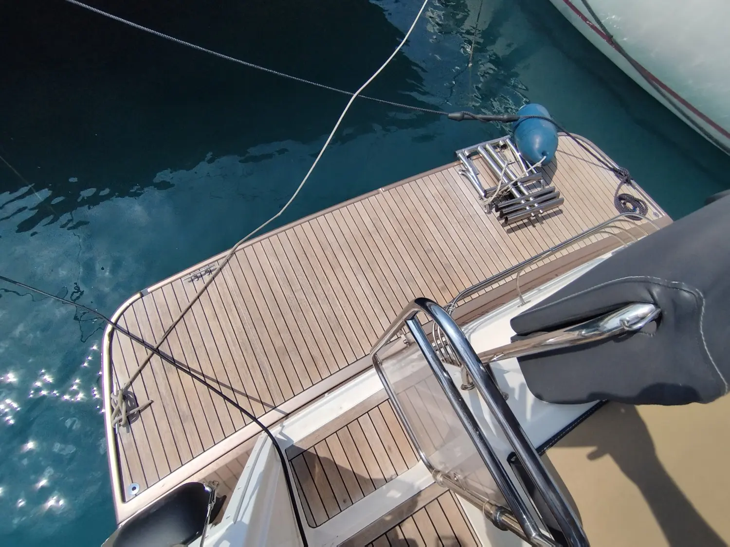 Delphia Escape 1100 Soley — Vue plongeante de la plateforme arrière avec échelle, pare-battage et cordages.