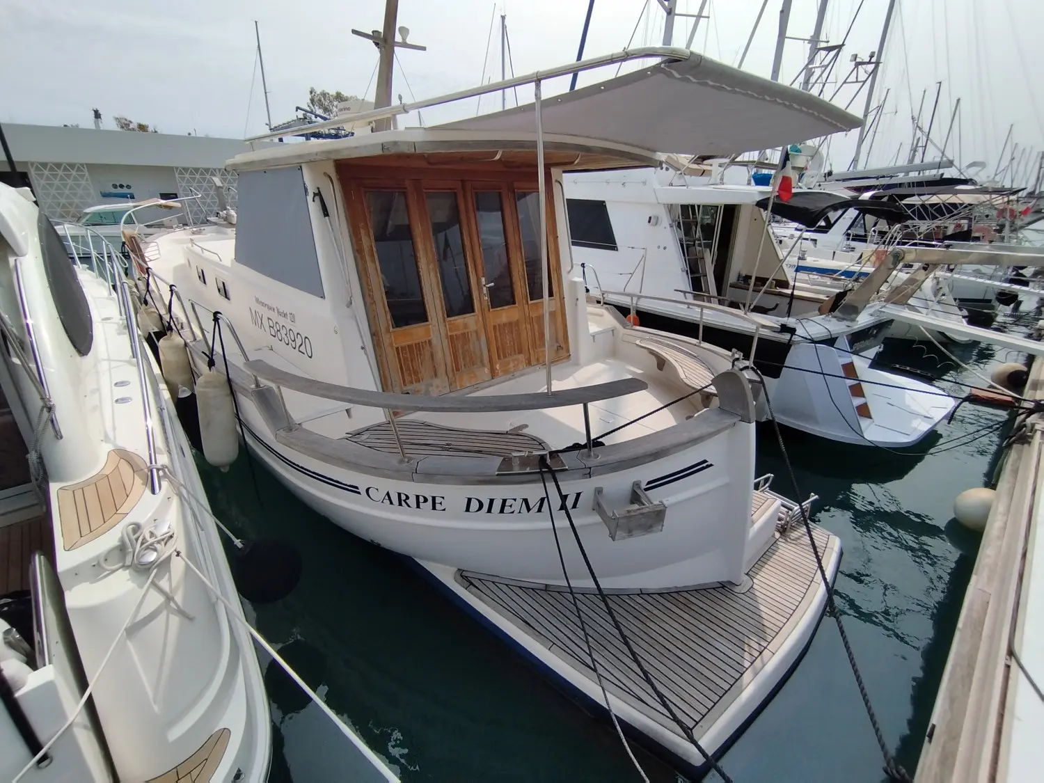Menorquin 120 — Bateau à moteur amarré dans une marina, vu depuis l’arrière.