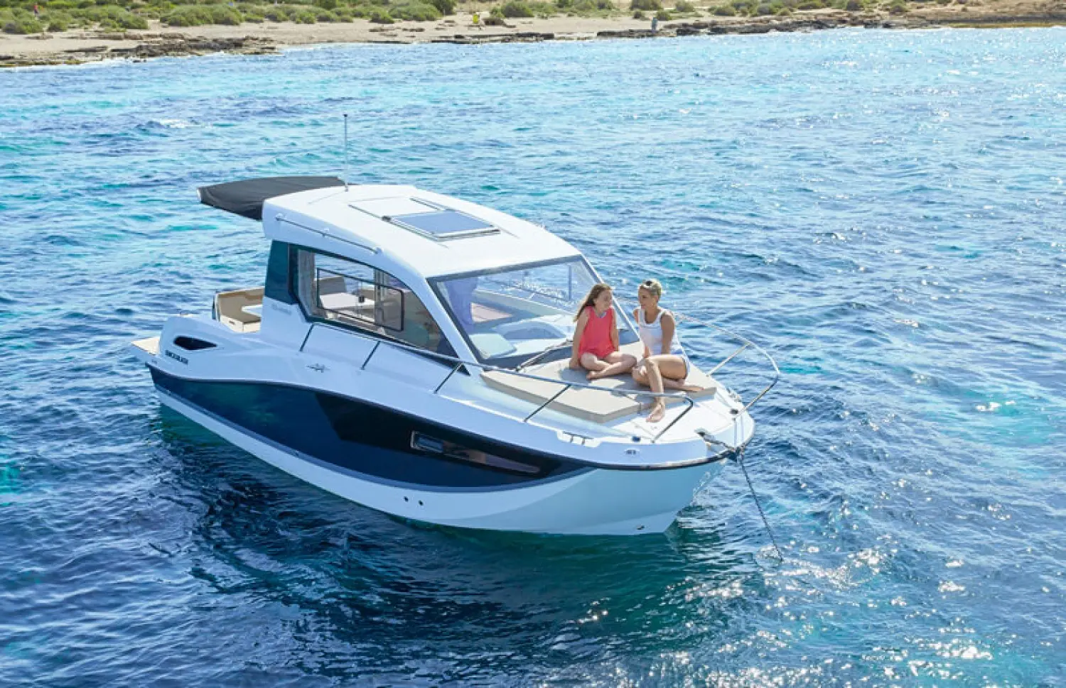 Quicksilver Activ 755 Weekend — Bateau blanc et bleu vu de trois quarts sur l’eau, avec deux personnes à l’avant.
