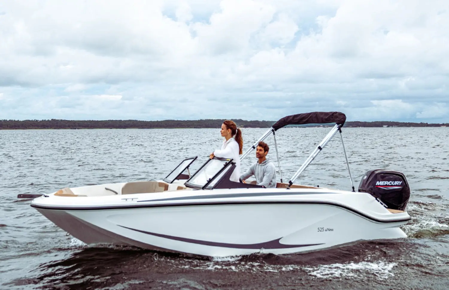 Quicksilver Activ 525 Axess — Bateau à moteur blanc vu de profil sur l’eau, avec deux personnes à bord.
