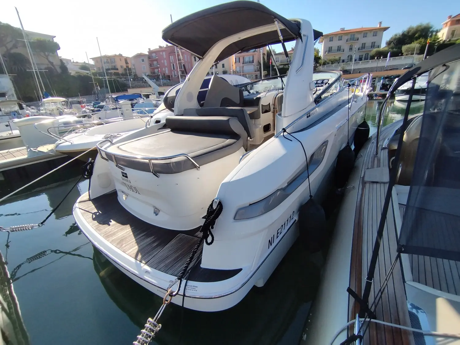 Bavaria 28 Sport — Vedette blanche amarrée dans un port, vue en trois quarts arrière.