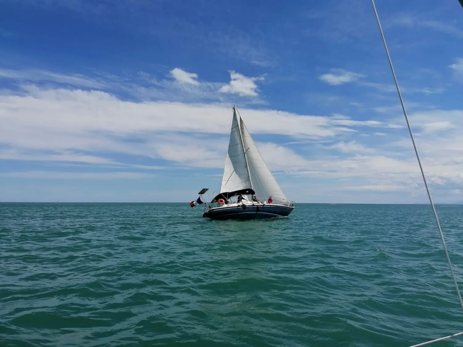CNSO Karate — Voilier naviguant au large, vu de trois quarts sous voiles.