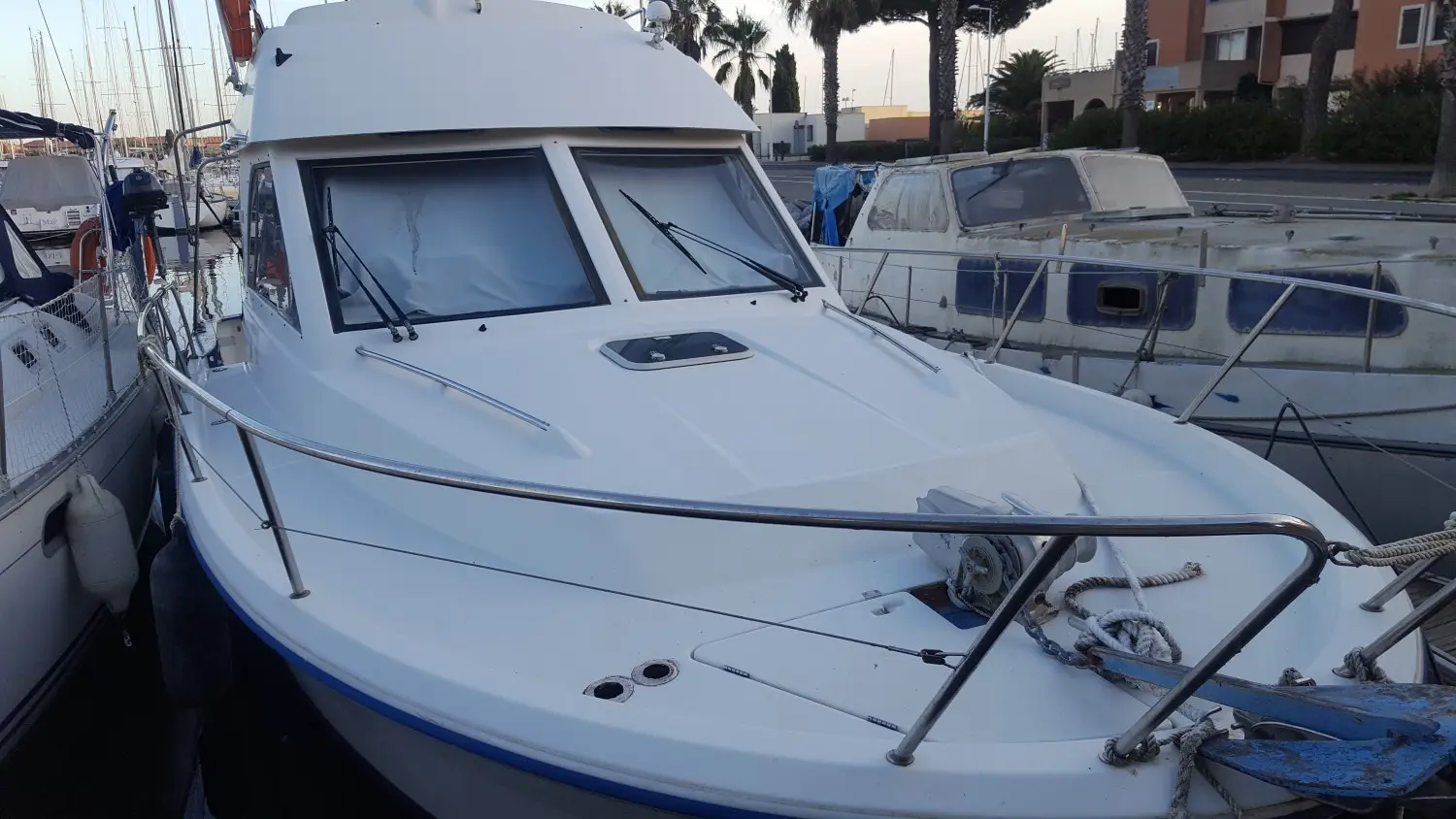 Beneteau Antares 905 — Vue rapprochée de l’avant et de la cabine d’un bateau amarré au port.
