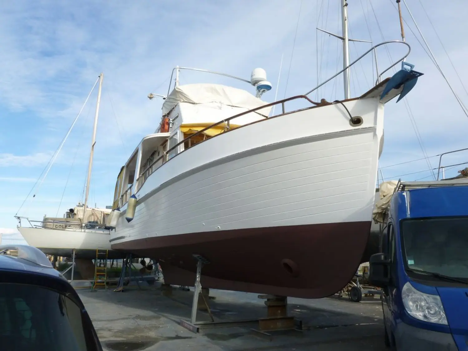 Grand Banks 42 Europa — Bateau à moteur blanc et bleu présenté à terre dans un chantier naval.