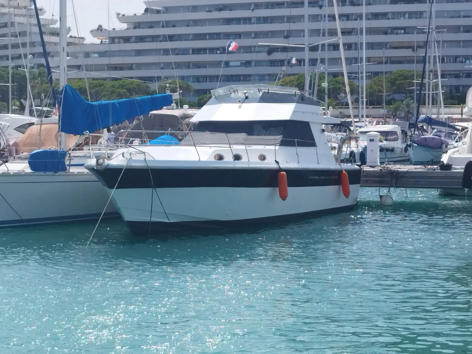 Princess 37 — Bateau à moteur blanc amarré dans une marina, vu de trois quarts avant.