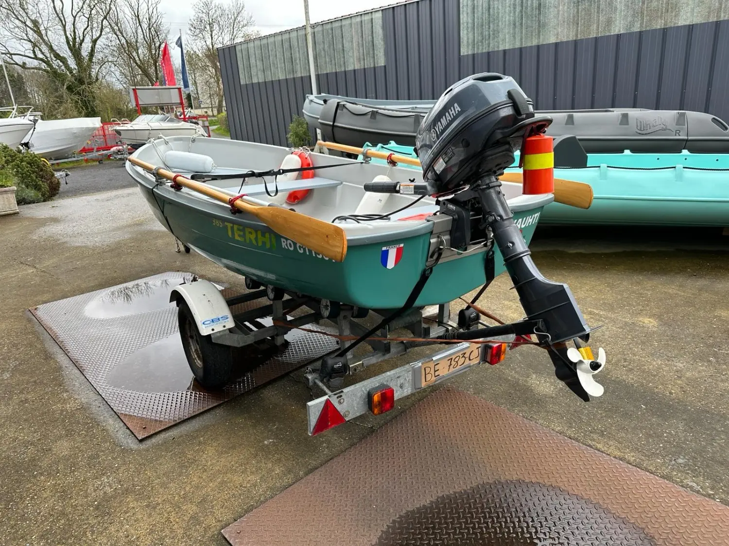 Terhi 385 — Petite embarcation verte équipée d’un moteur hors-bord, présentée sur sa remorque.