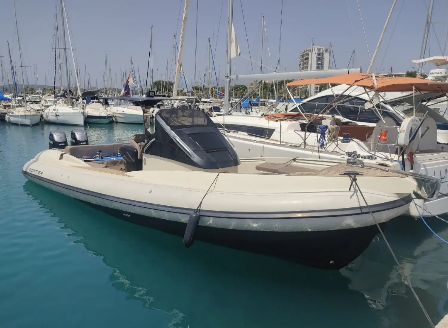 Scanner Envy 1100 Hb — Bateau semi-rigide blanc à deux moteurs amarré dans une marina.