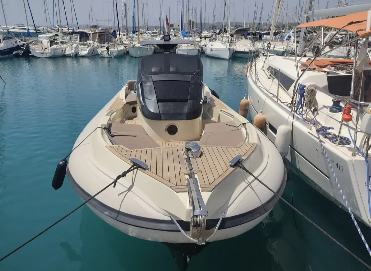 Scanner Envy 1100 Hb — Bateau à moteur amarré dans un port, vu de l’avant.