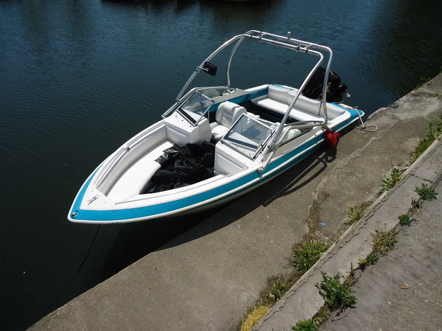 Larson All American 190 — Bateau de plaisance bleu et blanc amarré le long d’un quai.