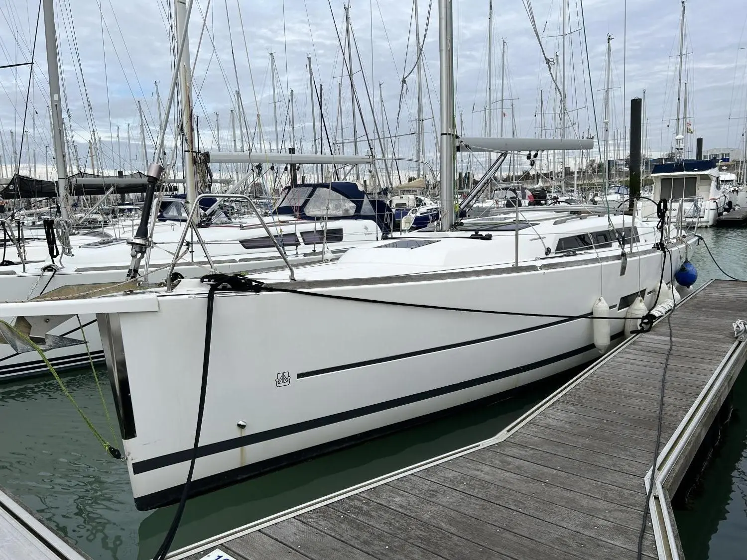 Dufour 350 — Voilier blanc amarré à un ponton dans une marina, vu de trois quarts bâbord.