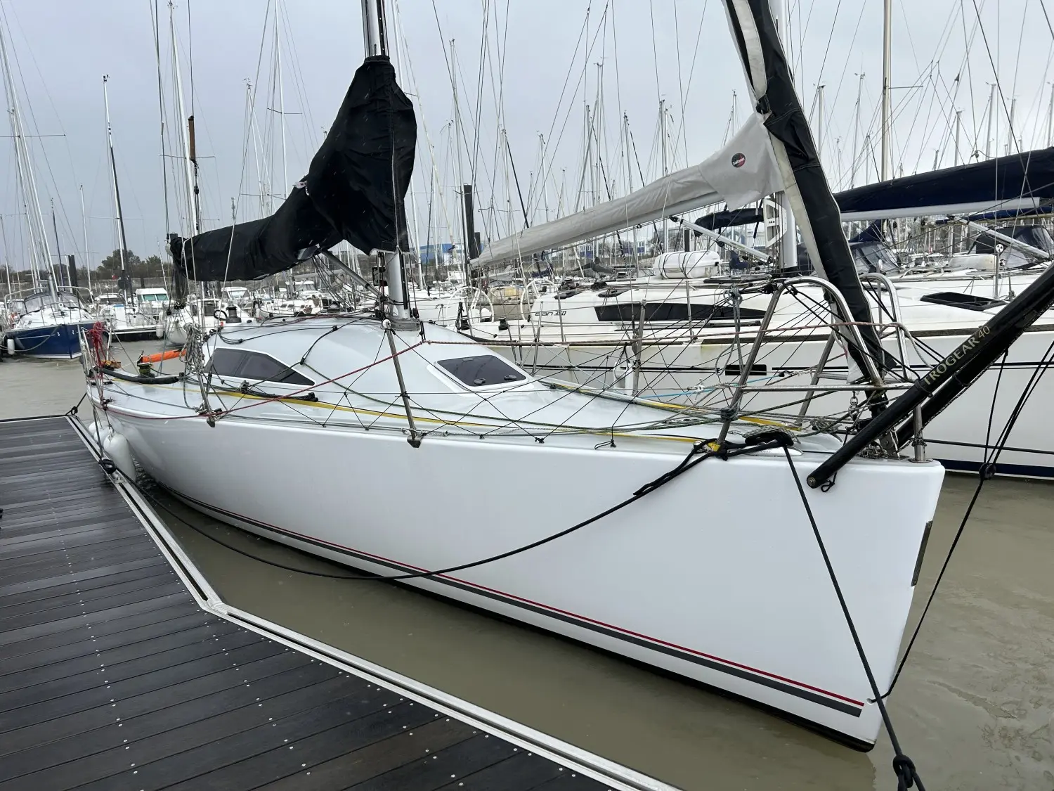 Carroll Marine Mumm 36 — Voilier blanc amarré dans une marina, vu de trois quarts par l’avant.