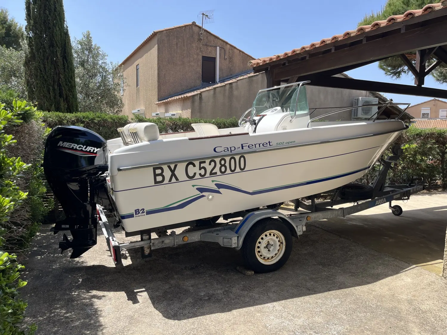 B2 Marine Cap Ferret 502 — Bateau à moteur blanc Cap-Ferret 502 open sur remorque, vu de trois quarts.