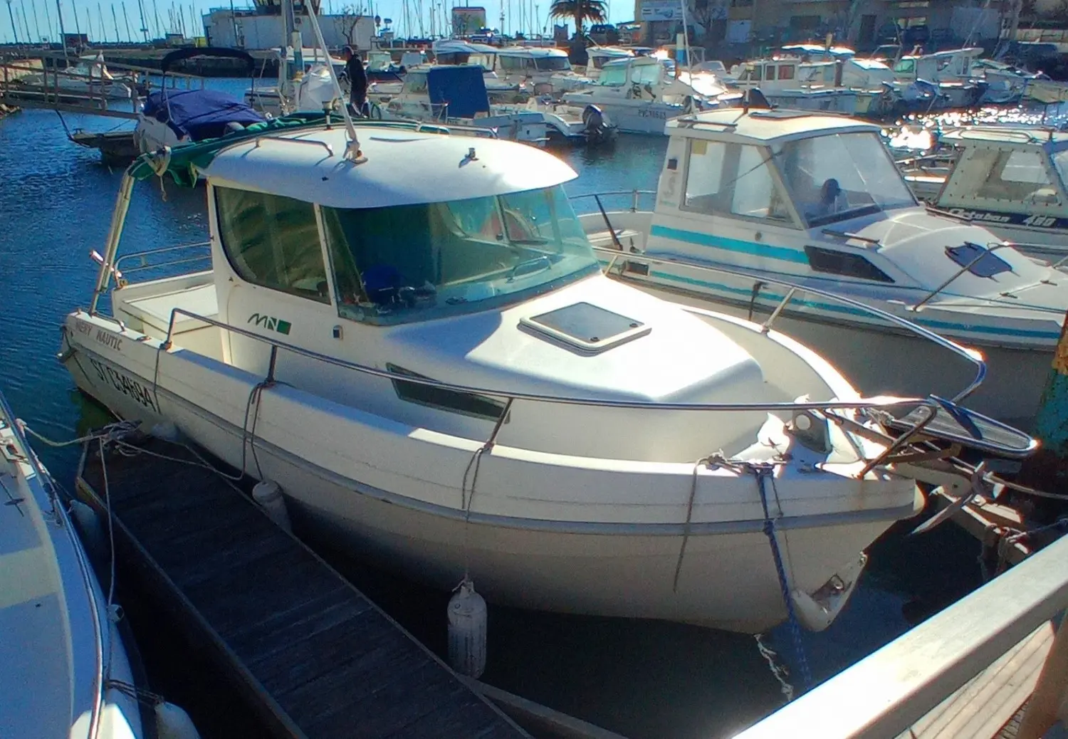 Mery Nautic Eyrac 600 — Bateau à cabine blanche amarré dans un port, vu de trois quarts avant.