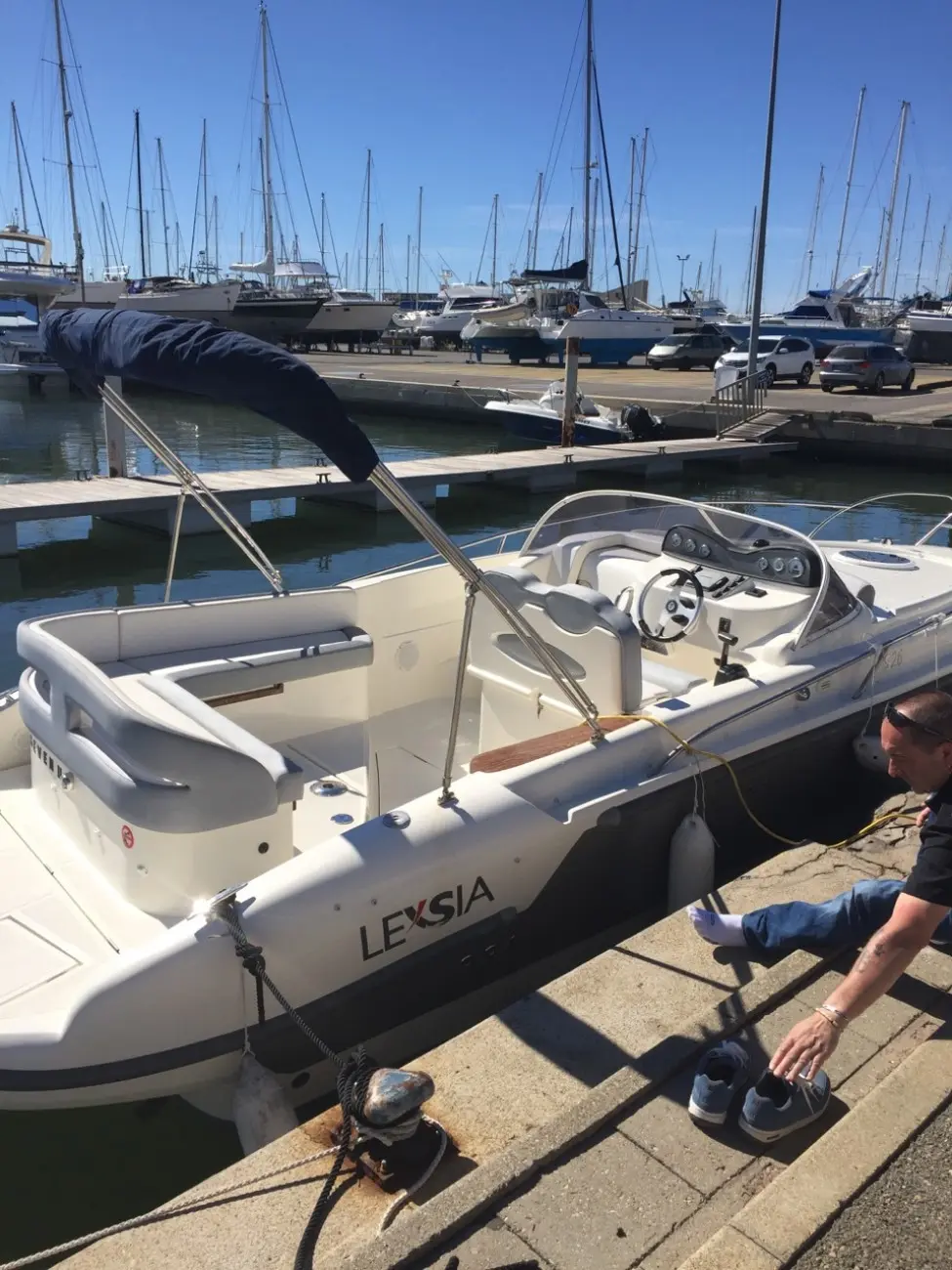 Lexsia XS26 — Bateau à moteur Lexsia amarré dans un port, avec console de pilotage visible.