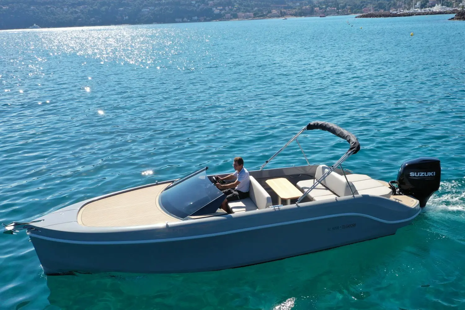 Rand Boats Spirit 25 — Vue en trois-quarts d’un bateau à moteur naviguant sur une eau turquoise