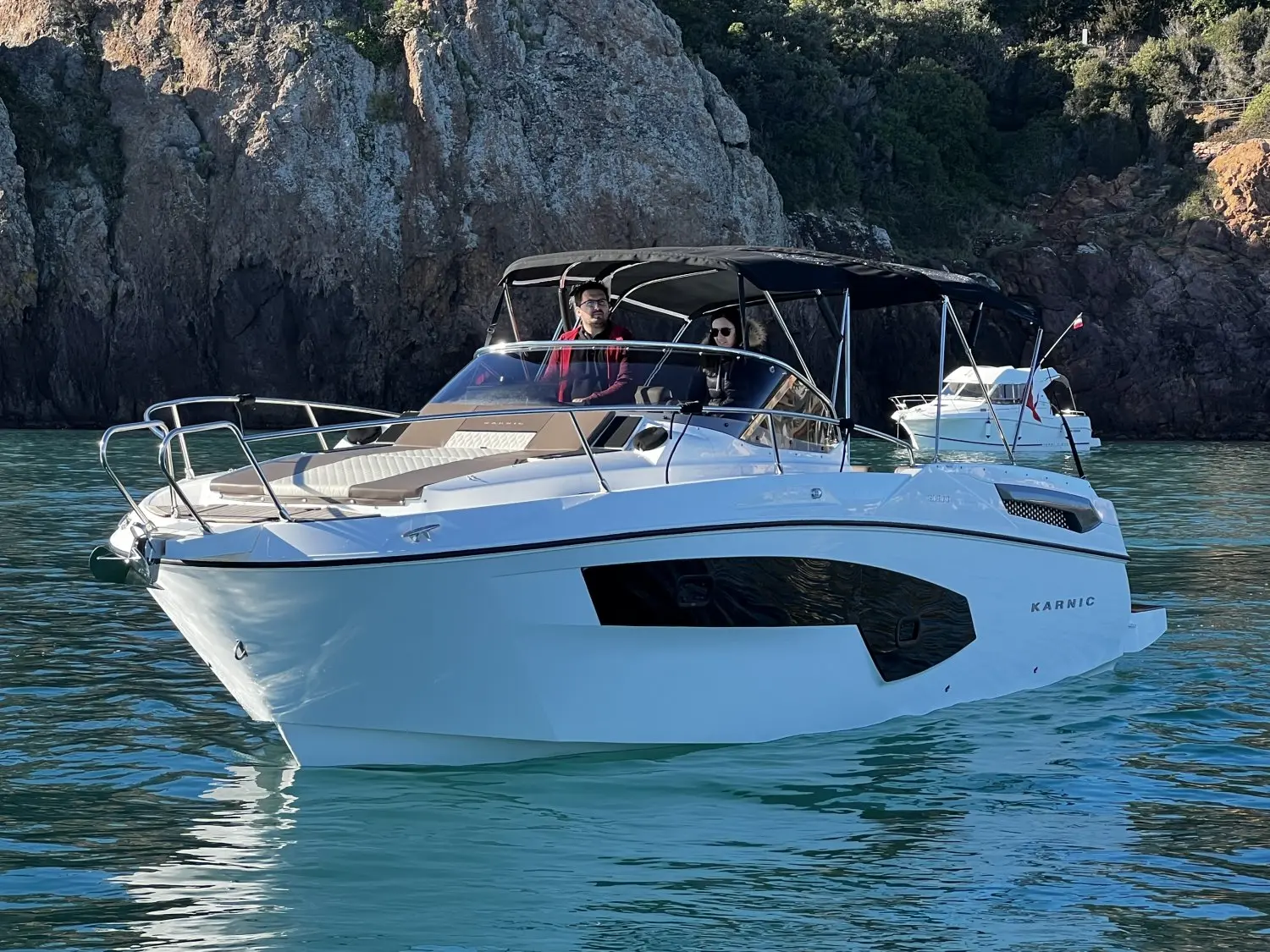 Karnic SL800 — Bateau à moteur blanc vu de trois quarts dans une crique rocheuse.