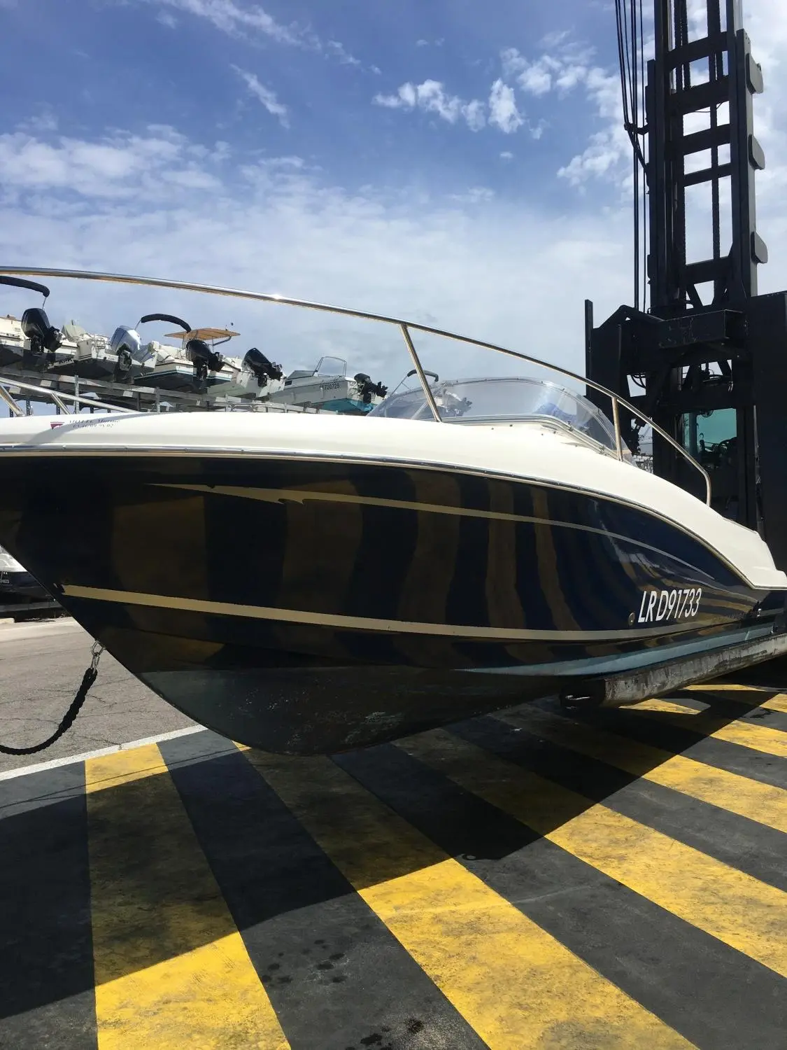 Jeanneau Cap Camarat 755 — Bateau à moteur vu de trois quarts sur une aire de manutention.