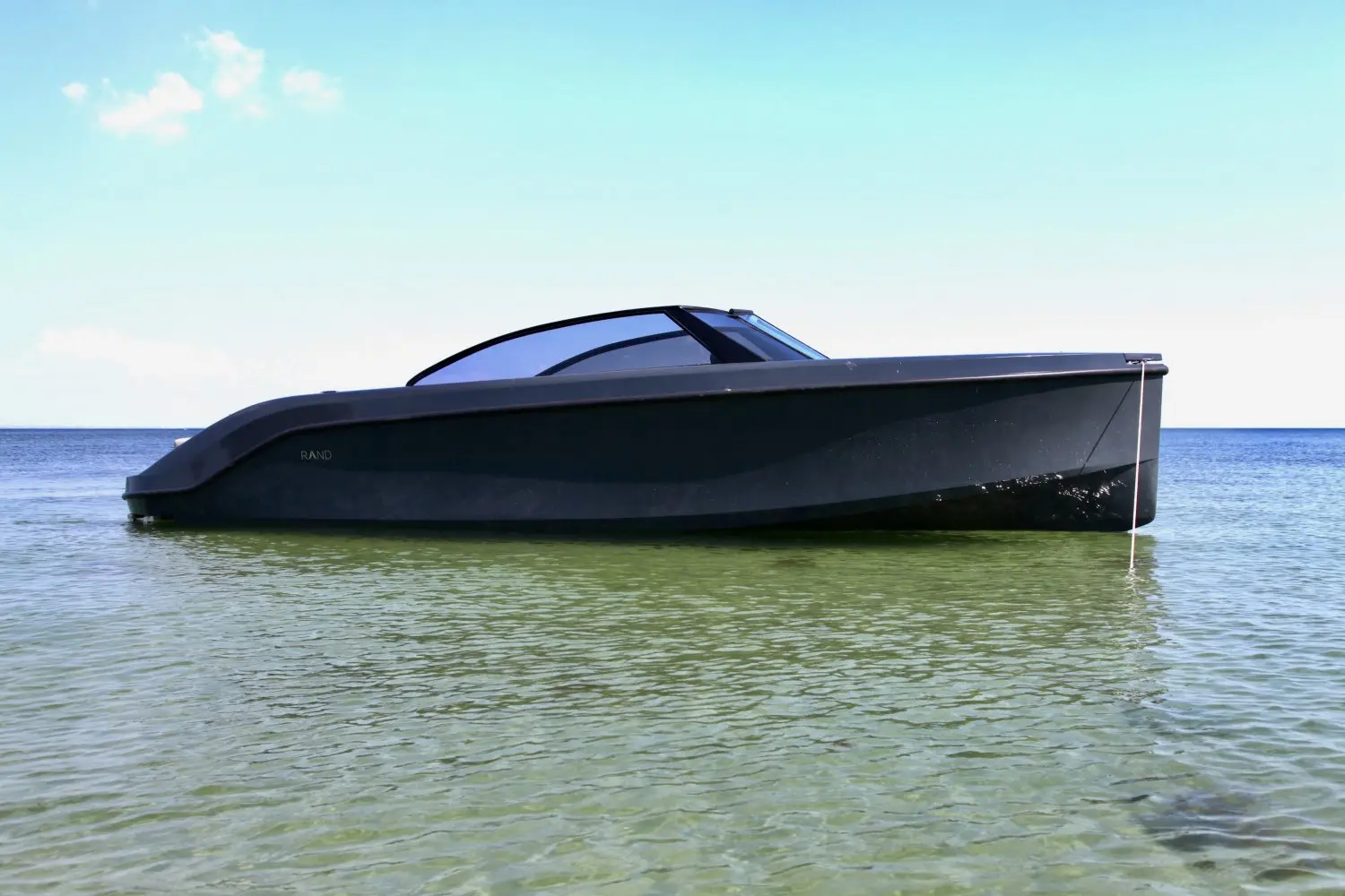 Rand Boats Leisure 28 — Bateau à moteur noir photographié de profil sur une mer calme.