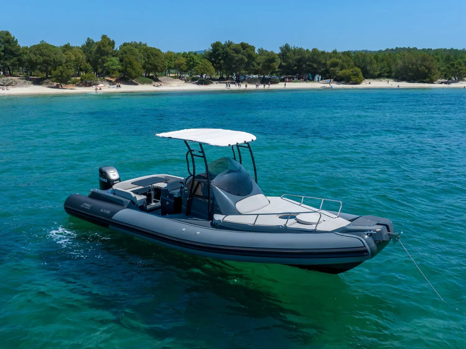 Fanale Altore 900 Cabine — Bateau semi-rigide gris photographié au mouillage devant une plage arborée.