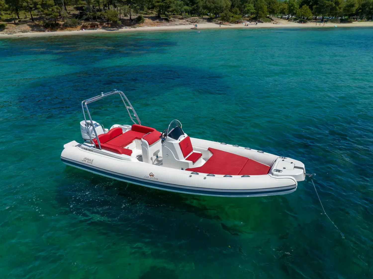 Fanale Falchettu — Bateau pneumatique blanc et rouge ancré dans une eau turquoise près d'une plage.