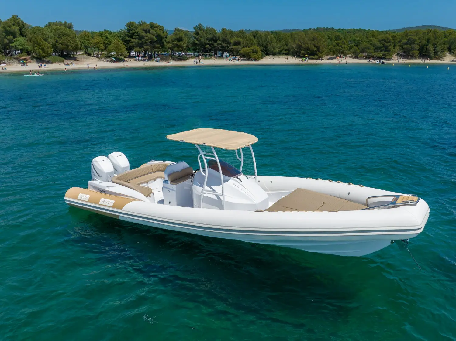 Fanale Libecciu 1000 — Bateau pneumatique blanc à double motorisation, photographié sur une eau turquoise.