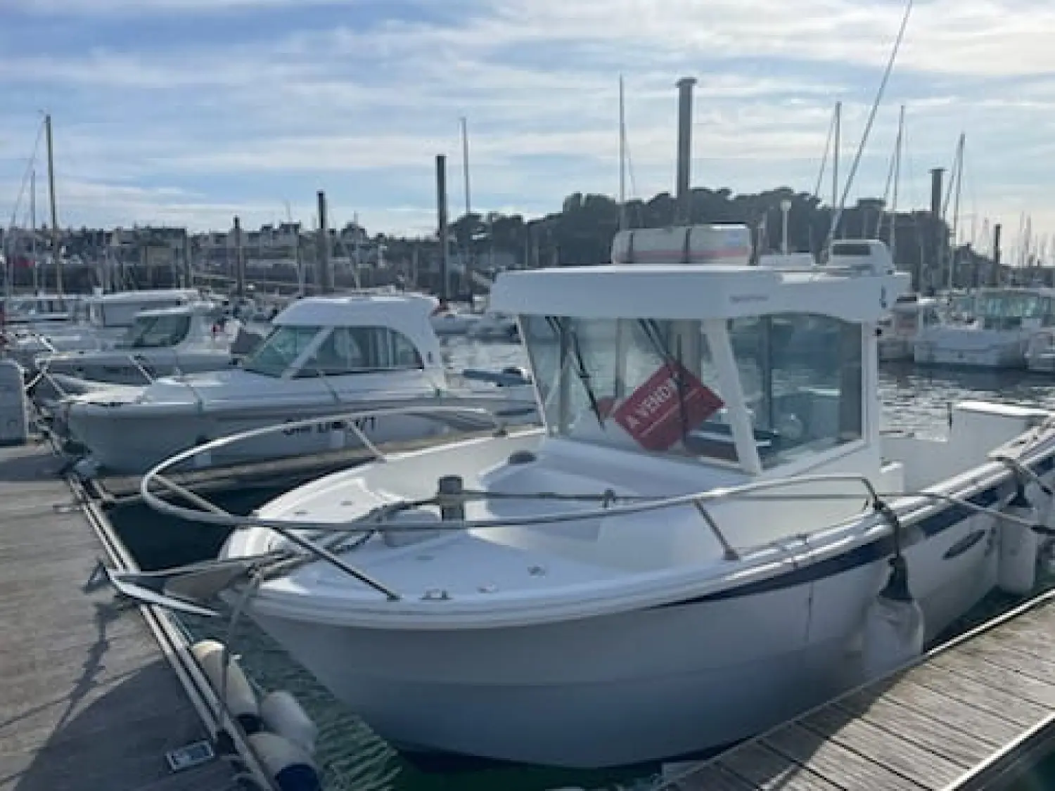 Beneteau Antares 700 Fishing — Bateau à moteur blanc à cabine amarré dans un port de plaisance.