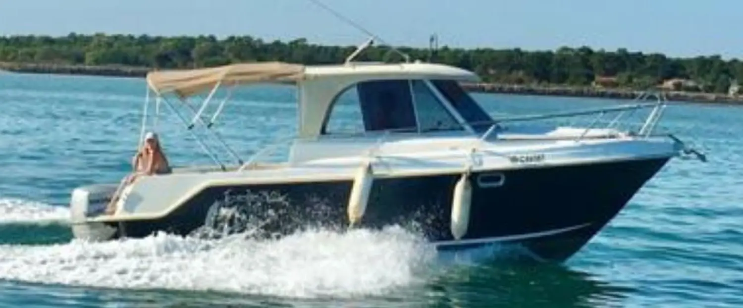 Guymarine Evada 740 — Bateau à moteur blanc naviguant sur une étendue d’eau, vu de trois quarts.