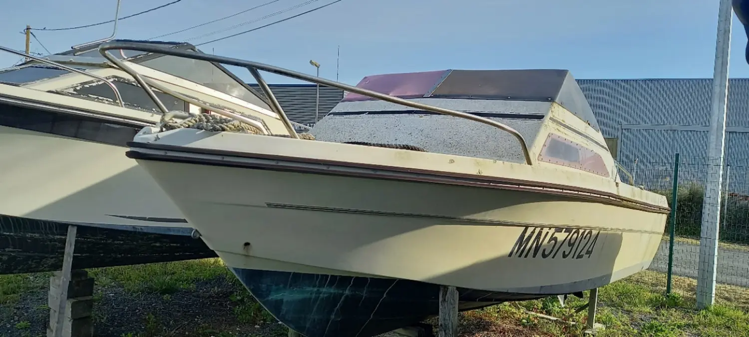Jeanneau Skanes 510 — Bateau à moteur blanc présenté sur bers dans une cour extérieure.