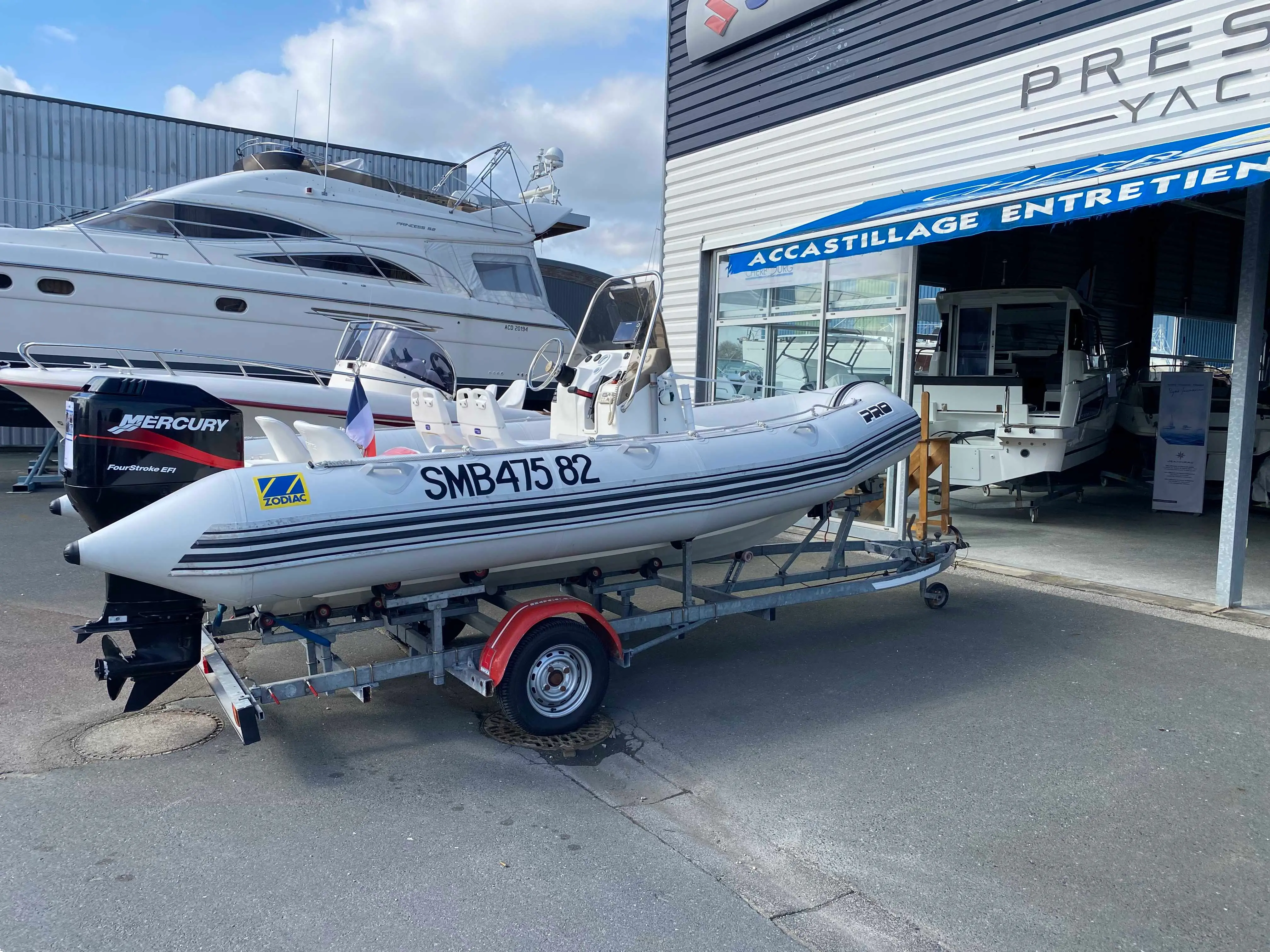 Zodiac Pro 550 — Semi-rigide blanc sur remorque, photographié devant un atelier nautique.