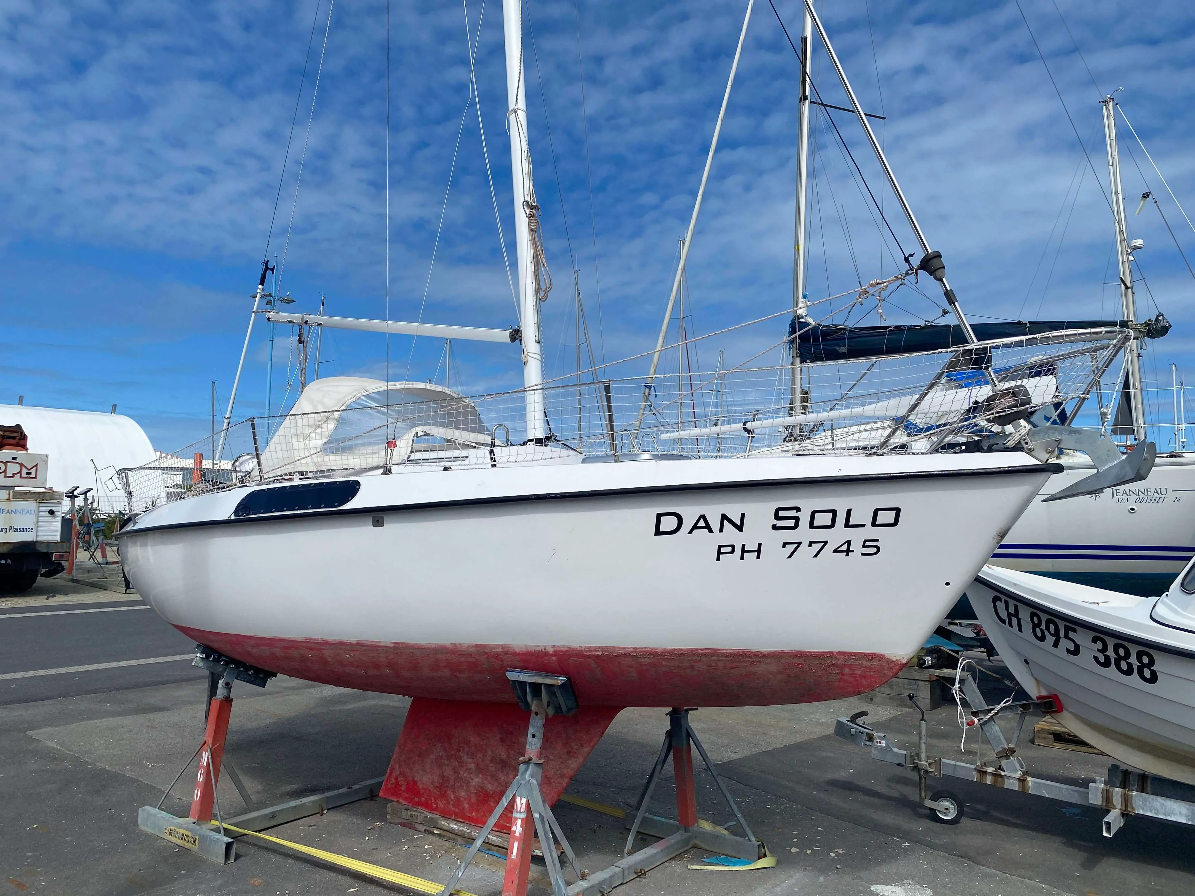 Kelt 620 — Voilier blanc photographié à terre sur bers, vu de profil bâbord.
