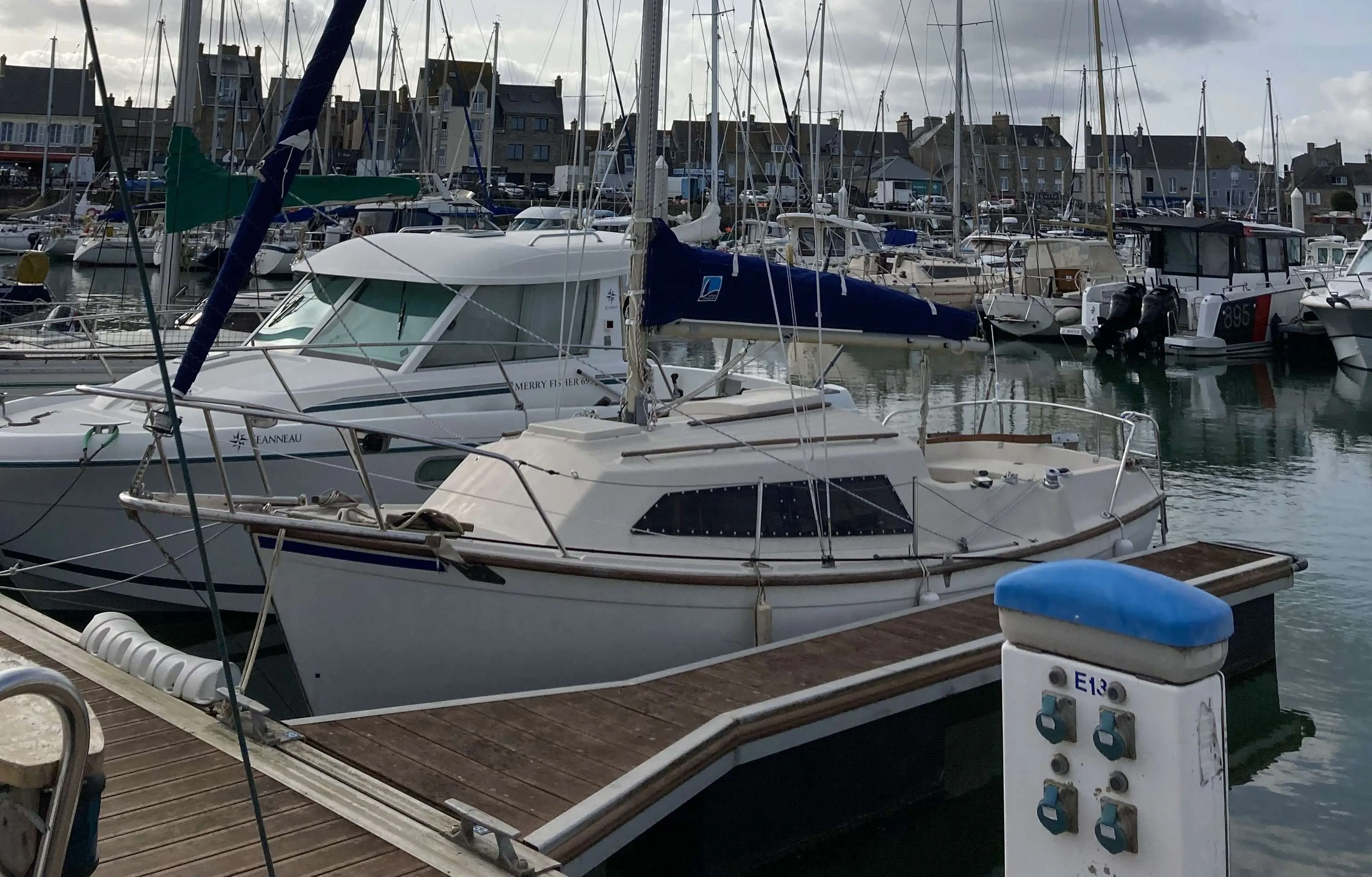 Beneteau Forban — Bateau à moteur blanc amarré dans un port de plaisance, vu de trois quarts.