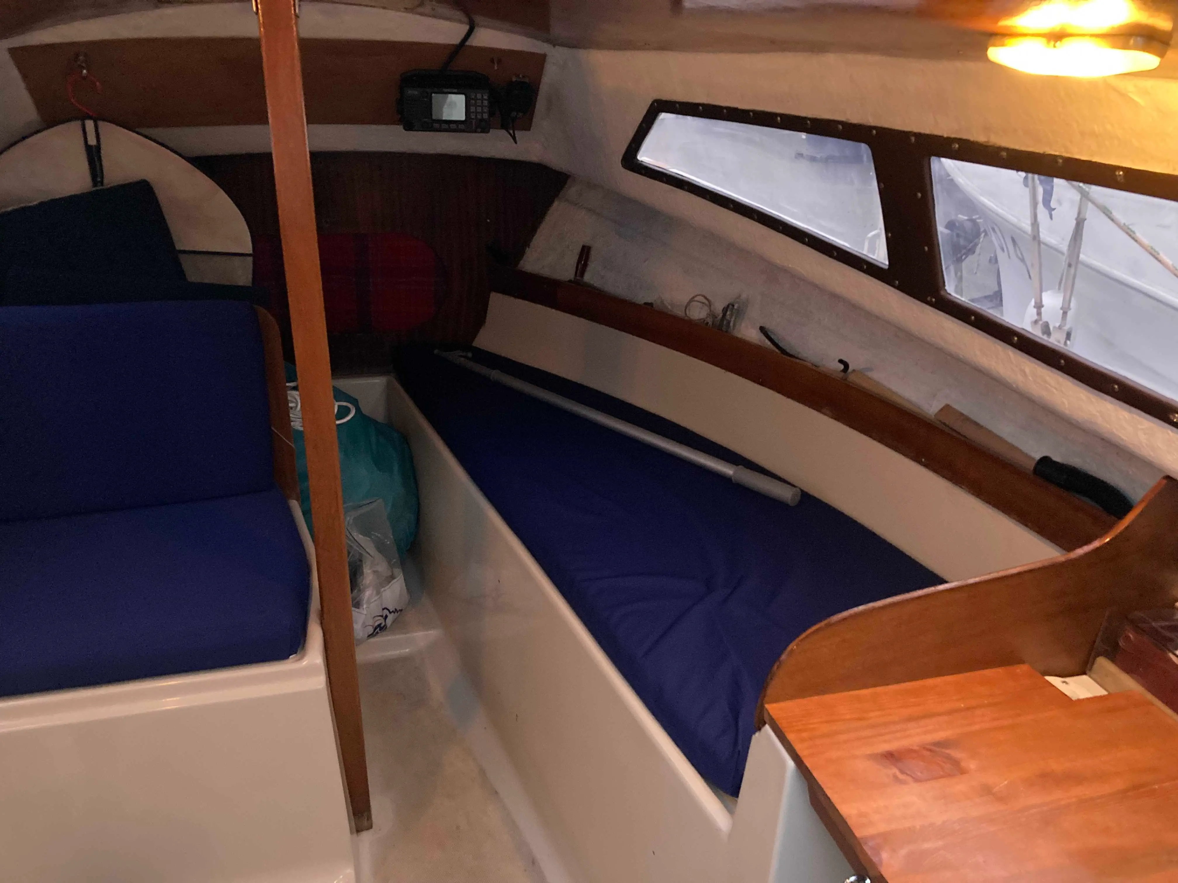 Beneteau Forban — Vue intérieure d'une cabine de bateau avec couchettes, hublots et instruments.