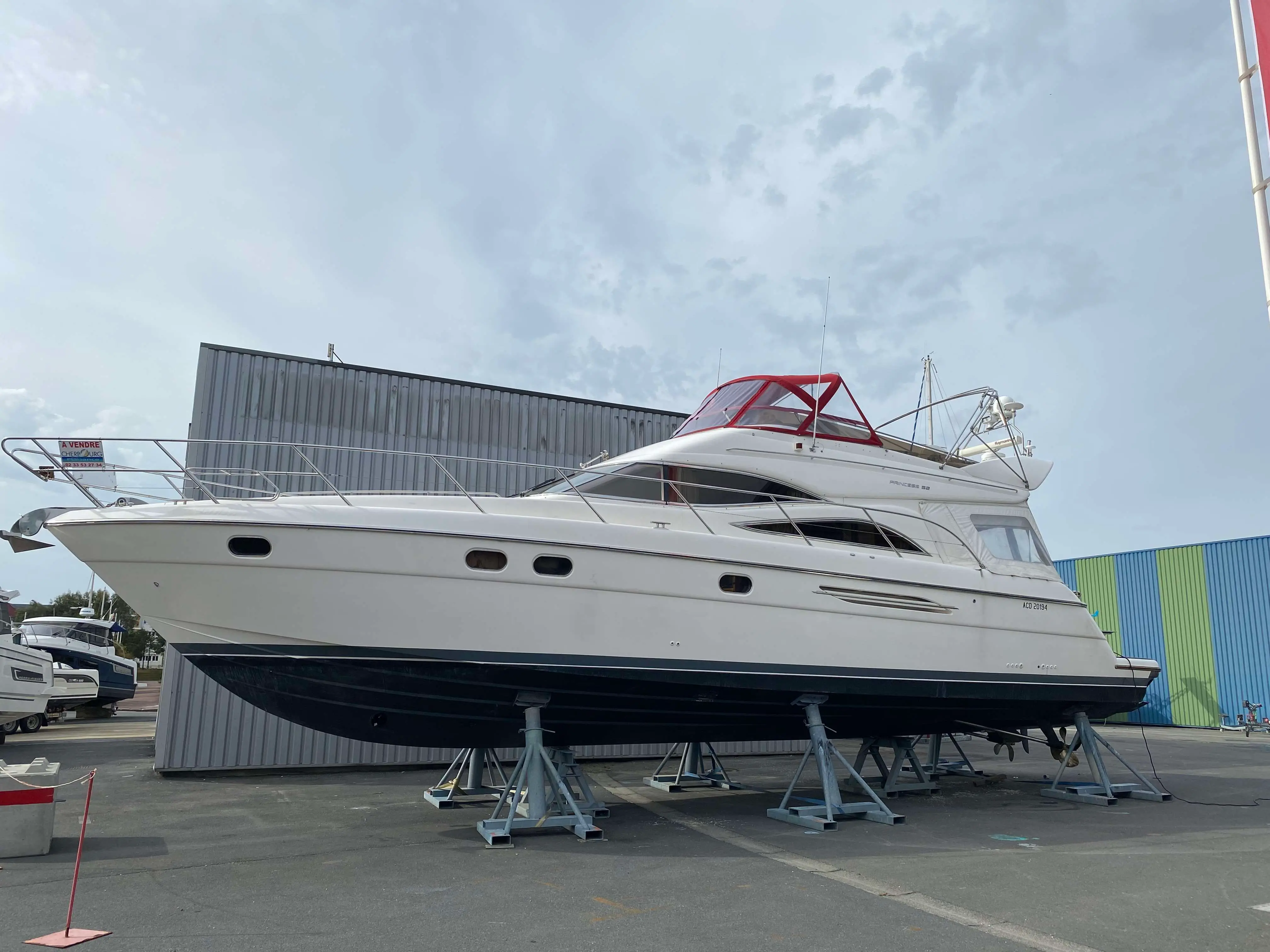 Princess 52 — Bateau à moteur blanc présenté à terre sur bers, vu de profil.