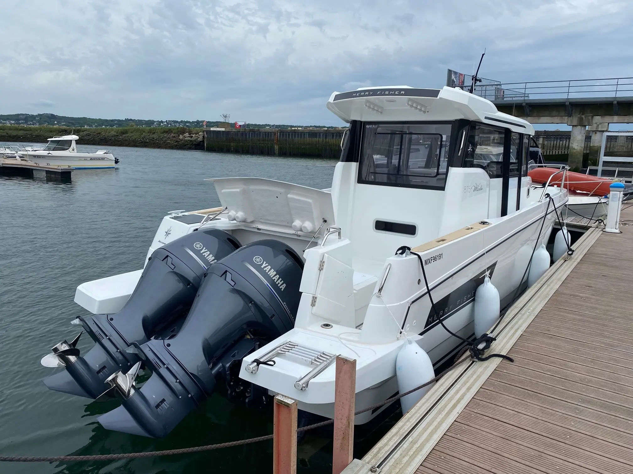 Jeanneau Merry Fisher 875 Marlin — Bateau à moteur amarré au ponton, vu de trois quarts arrière.