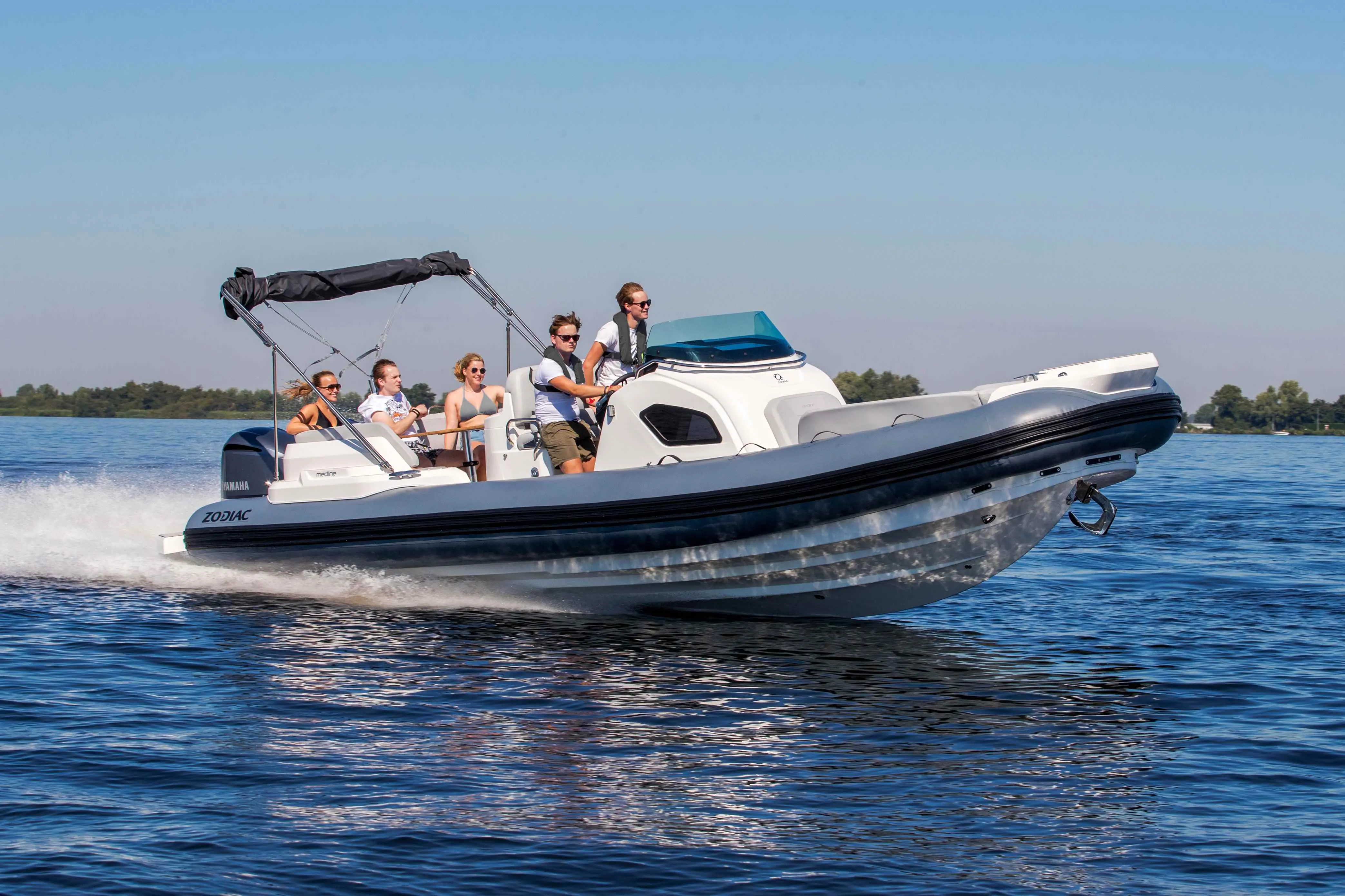 Zodiac Medline 9 — Bateau pneumatique semi-rigide naviguant sur un lac avec plusieurs passagers.